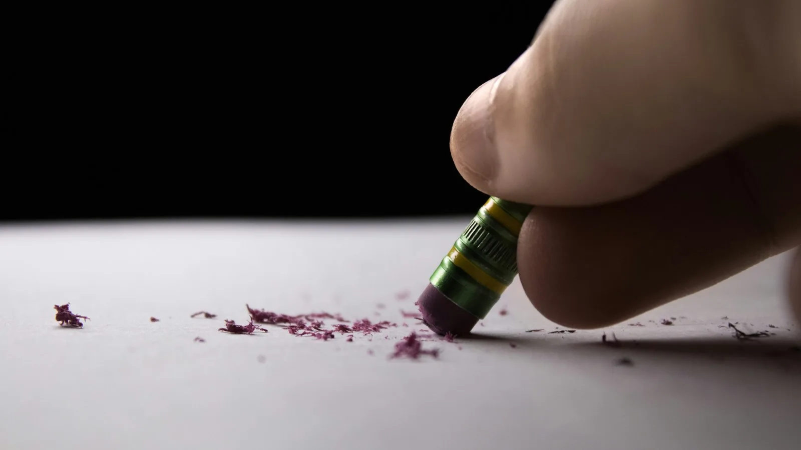 Une gomme au bout d'un crayon effaçant des traits sur une feuille, symbole de l'erreur que l'on corrige pour progresser